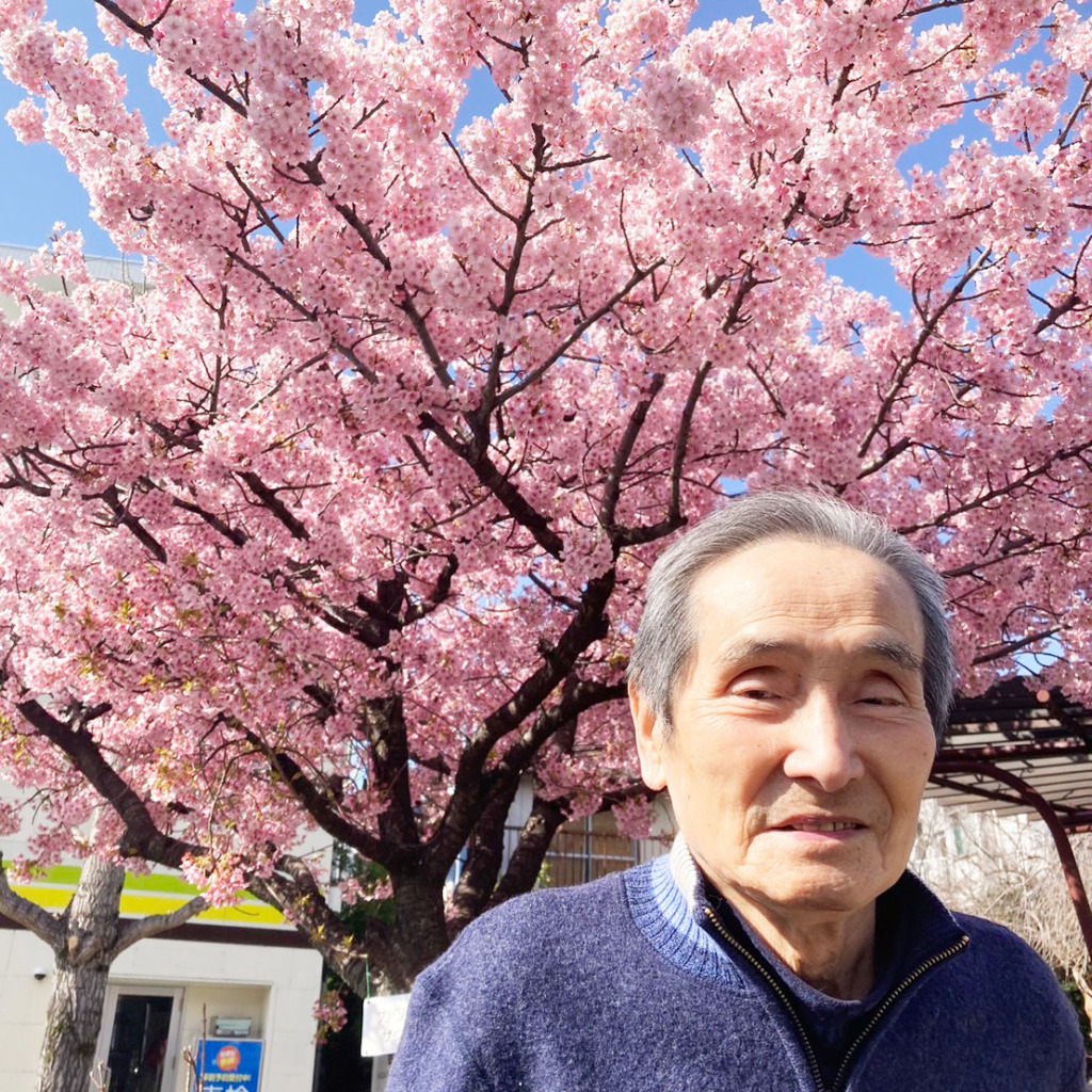 桜を背に写真に写る利用者さま１