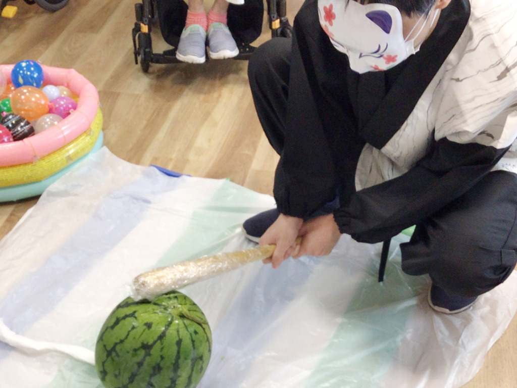 スイカに棒を振り下ろしている様子