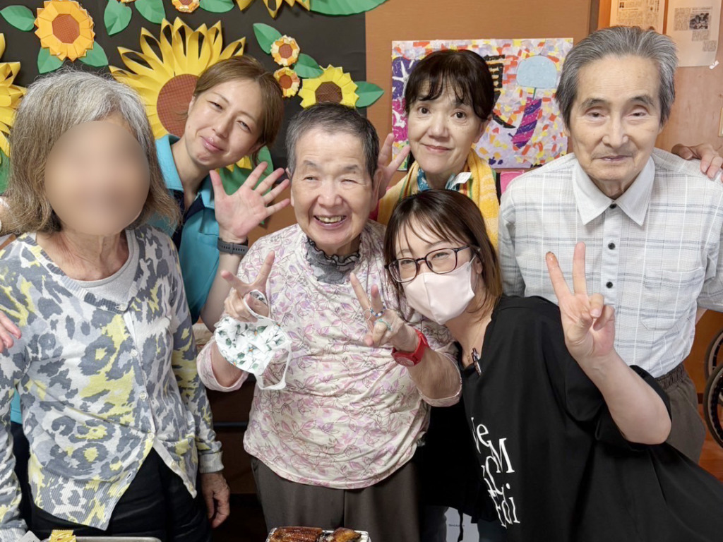 うなぎ祭りで集合写真を撮る利用者さまとスタッフたち