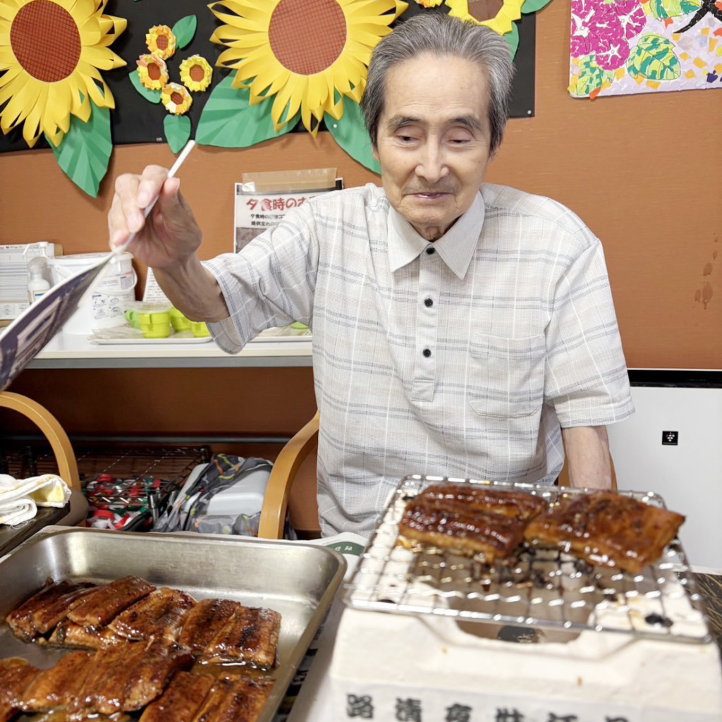 うなぎをうちわで扇ぐ利用者さま