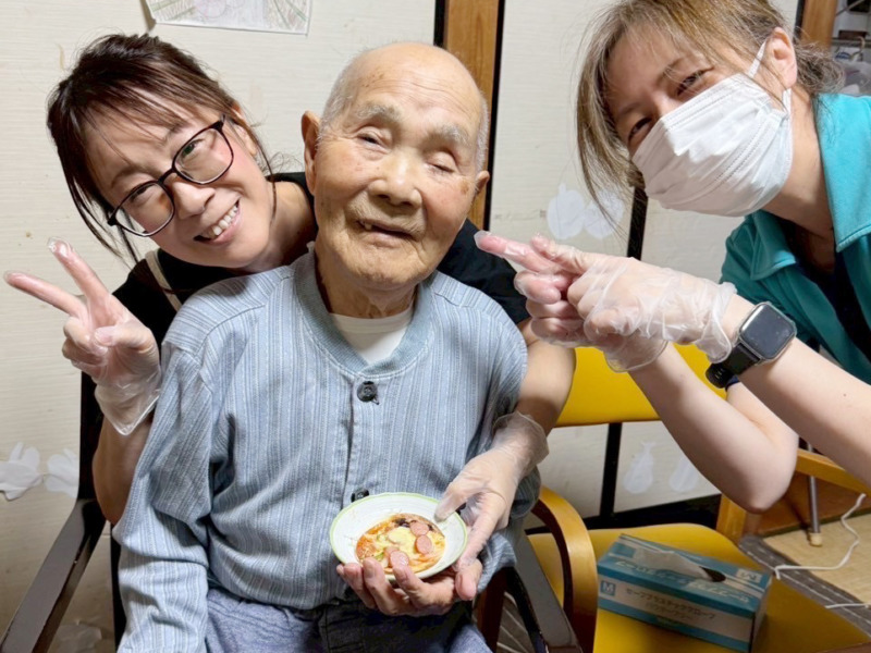 スタッフたちの間で笑顔の利用者さま