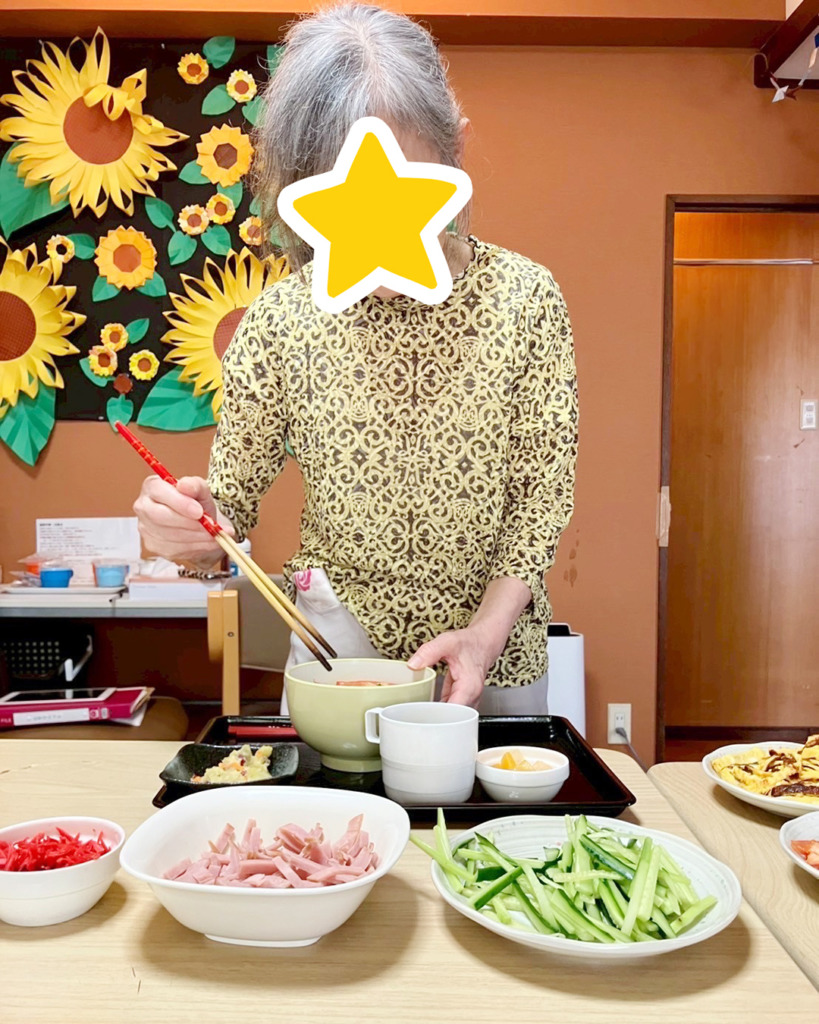 好みの具材を冷やし中華に盛り付ける利用者さま