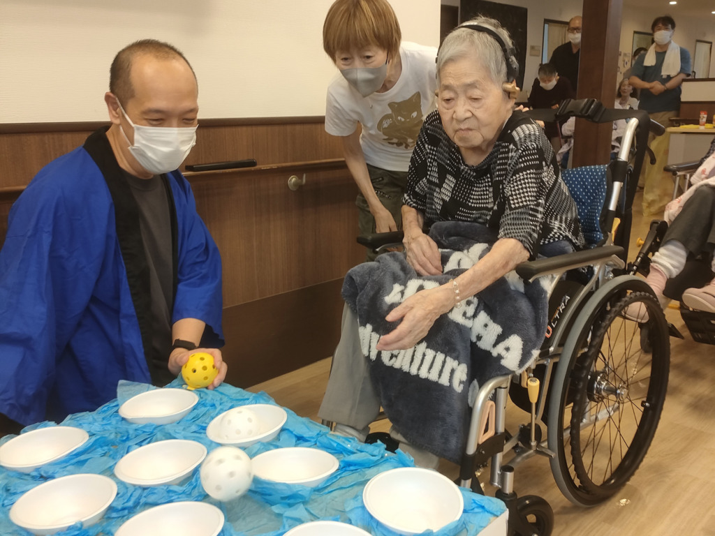 夏祭りのボール投げの露店を遊ぶ利用者さま