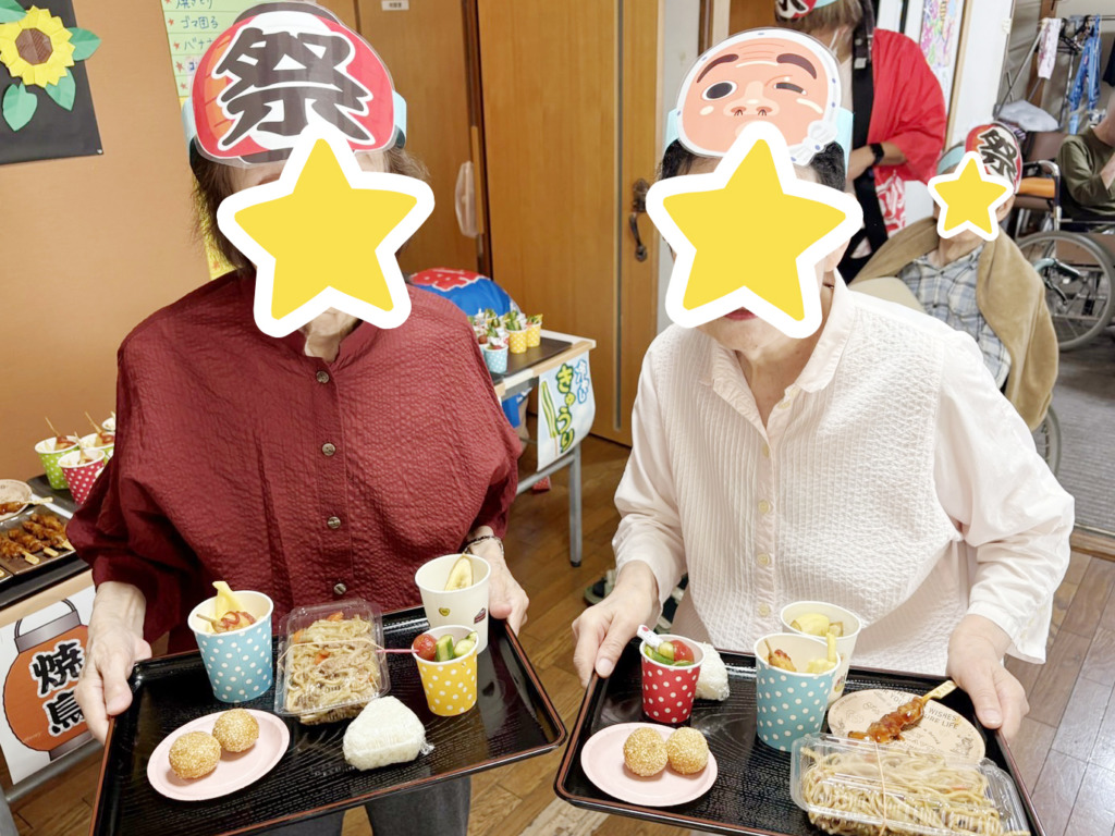 屋台の料理を盛りつけたおぼんを持つ利用者さまたち