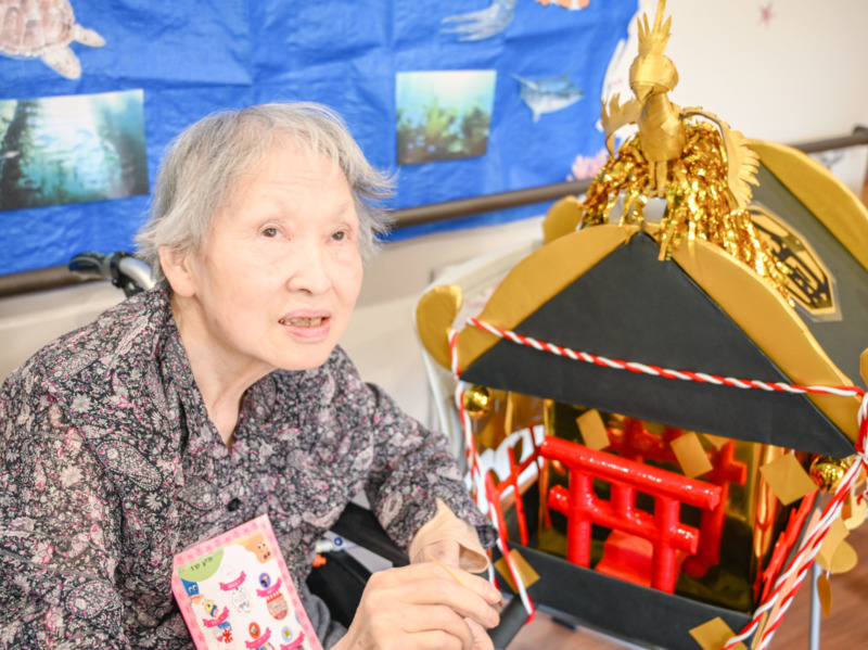 スタッフが作ったお神輿に並んで、写真に写る利用者さま