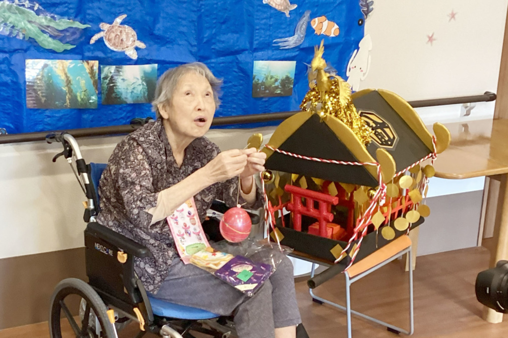 スタッフが作ったお神輿に並んで、写真に写る利用者さま