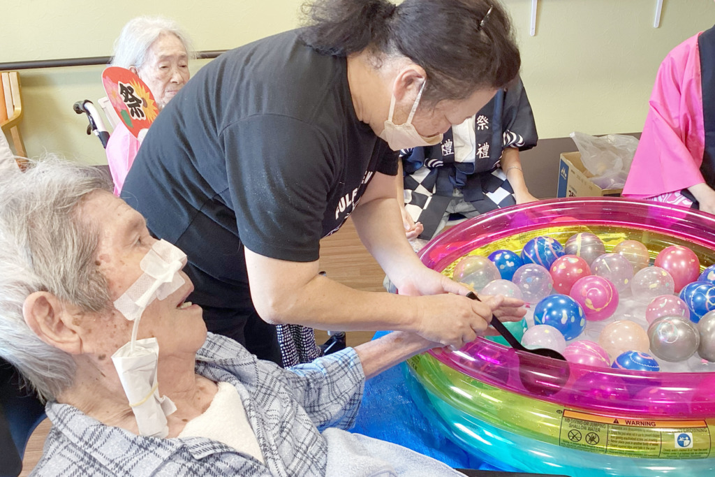 スタッフのサポートを受けてヨーヨー釣りをする利用者さま