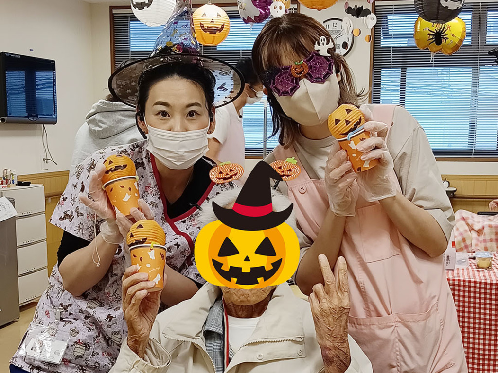 みのりあカフェのアフタヌーンティーを前に仮装して写真撮影する入居者さまとスタッフたち