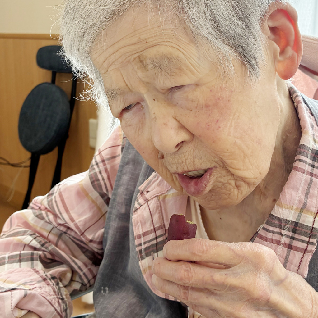 焼き芋を食べて笑顔の入居者さま
