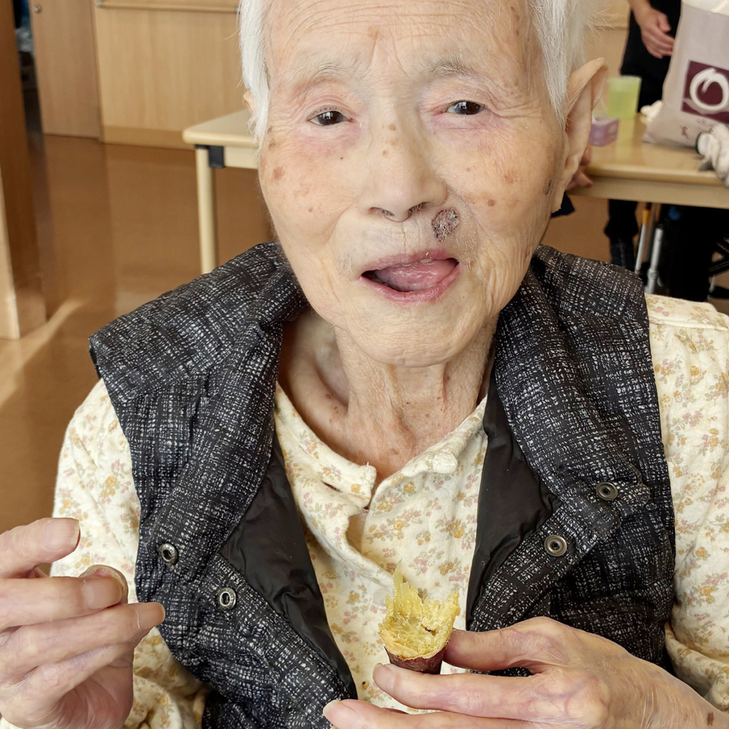 焼き芋を食べて笑顔の入居者さま
