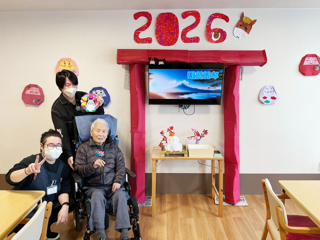 アクセサリーを付けてスタッフたちと一緒に鳥居の前で写真に写る入居者さま